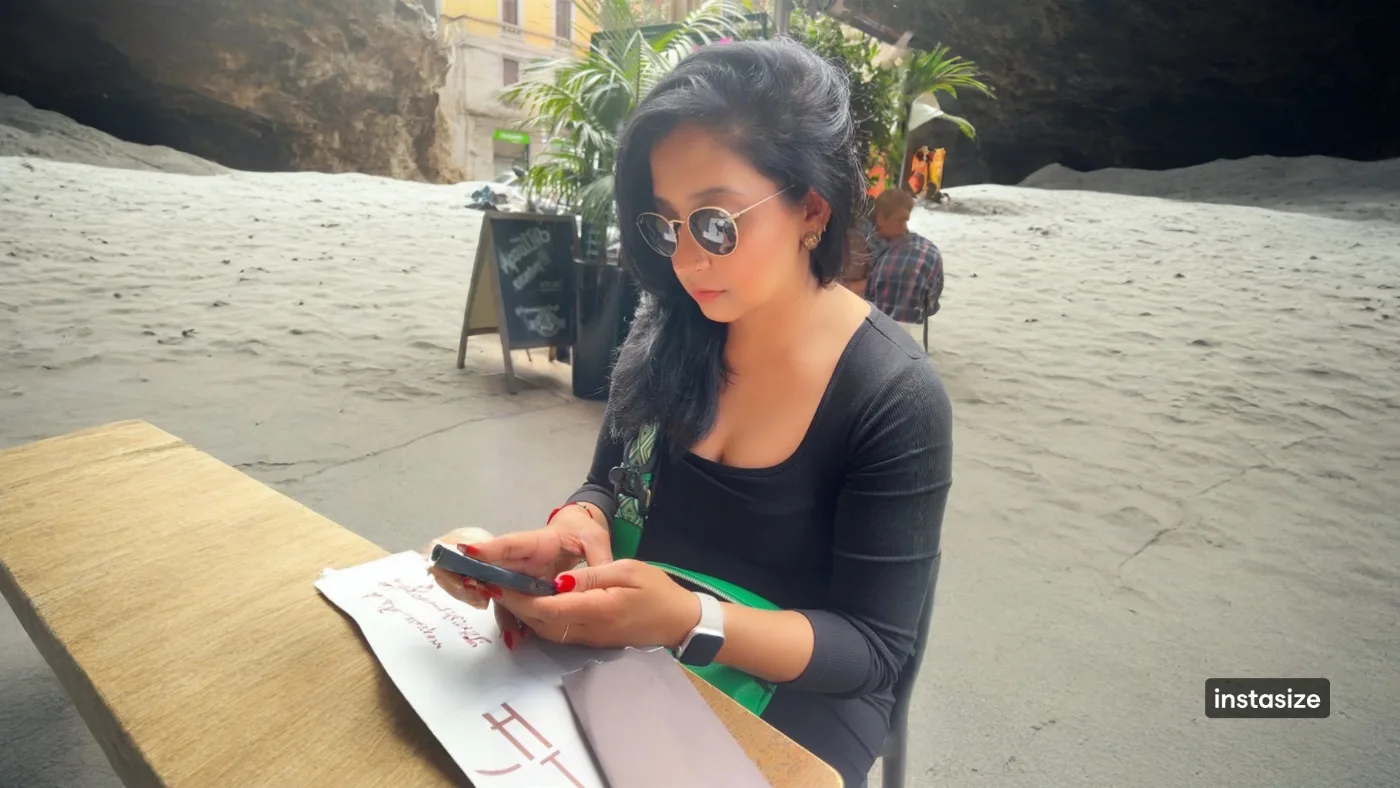 A girl sitting at a cafe in Milan working on her cellphone